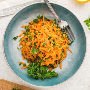 french carrot salad in blue plate with fork.