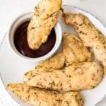 air fryer chicken tenders without breading on a plate with sauce.