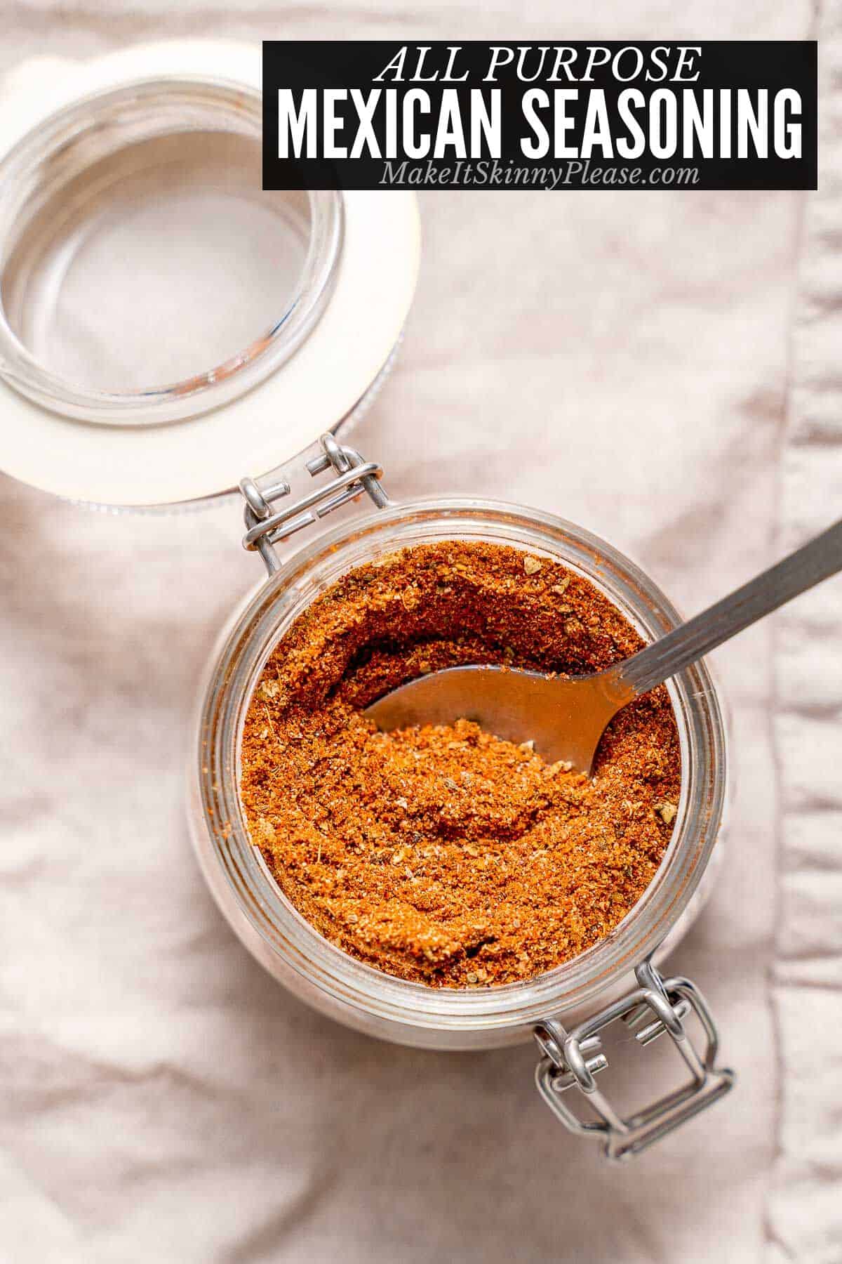all purpose mexican seasoning in a glass jar with spoon.