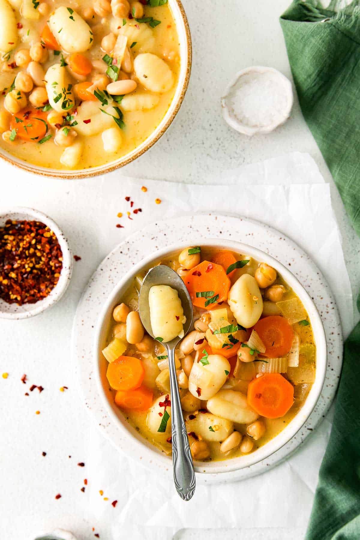 vegetable gnocchi soup in bowl with spoon.