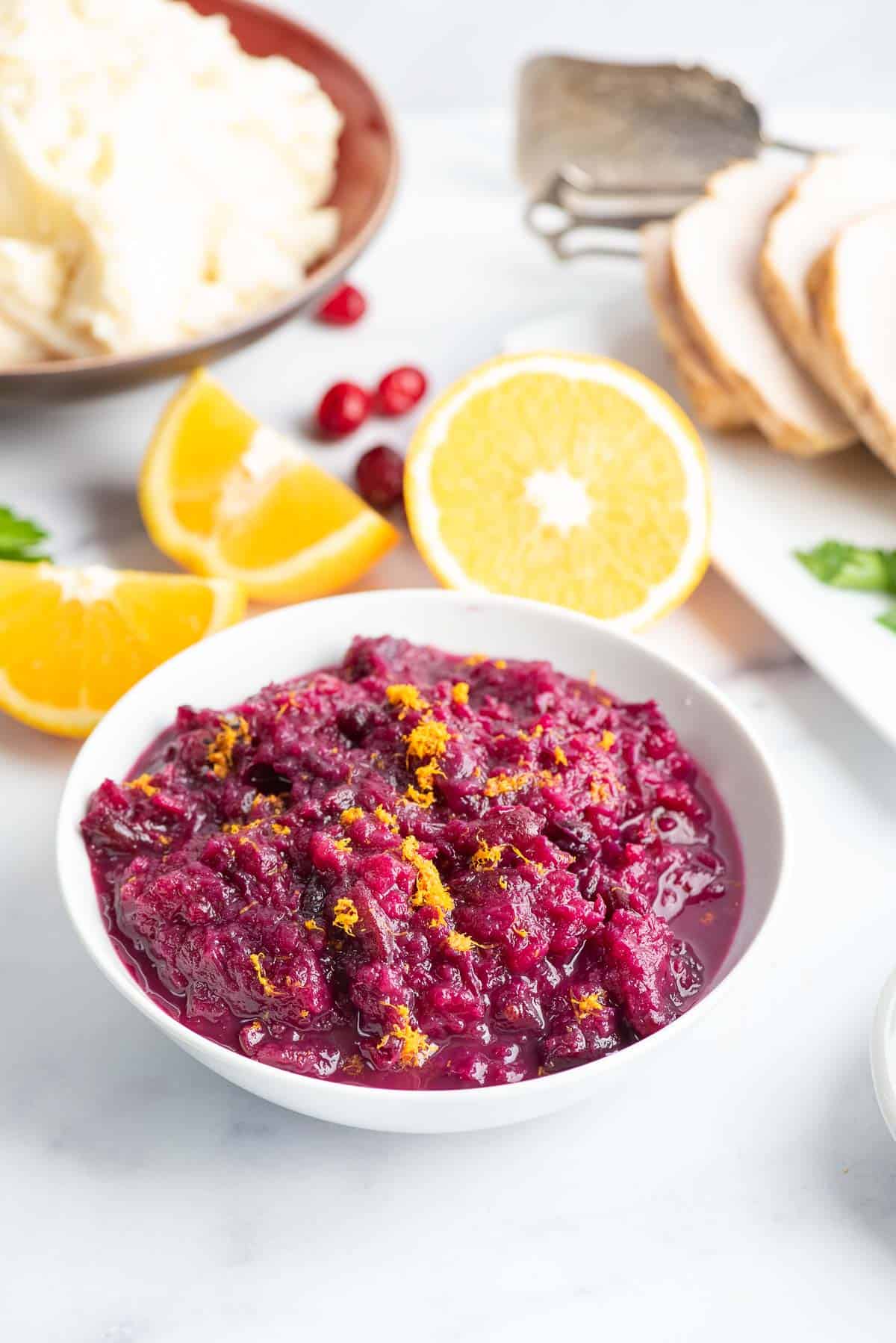 cranberry pineapple sauce in a bowl with thanksgiving dishes.
