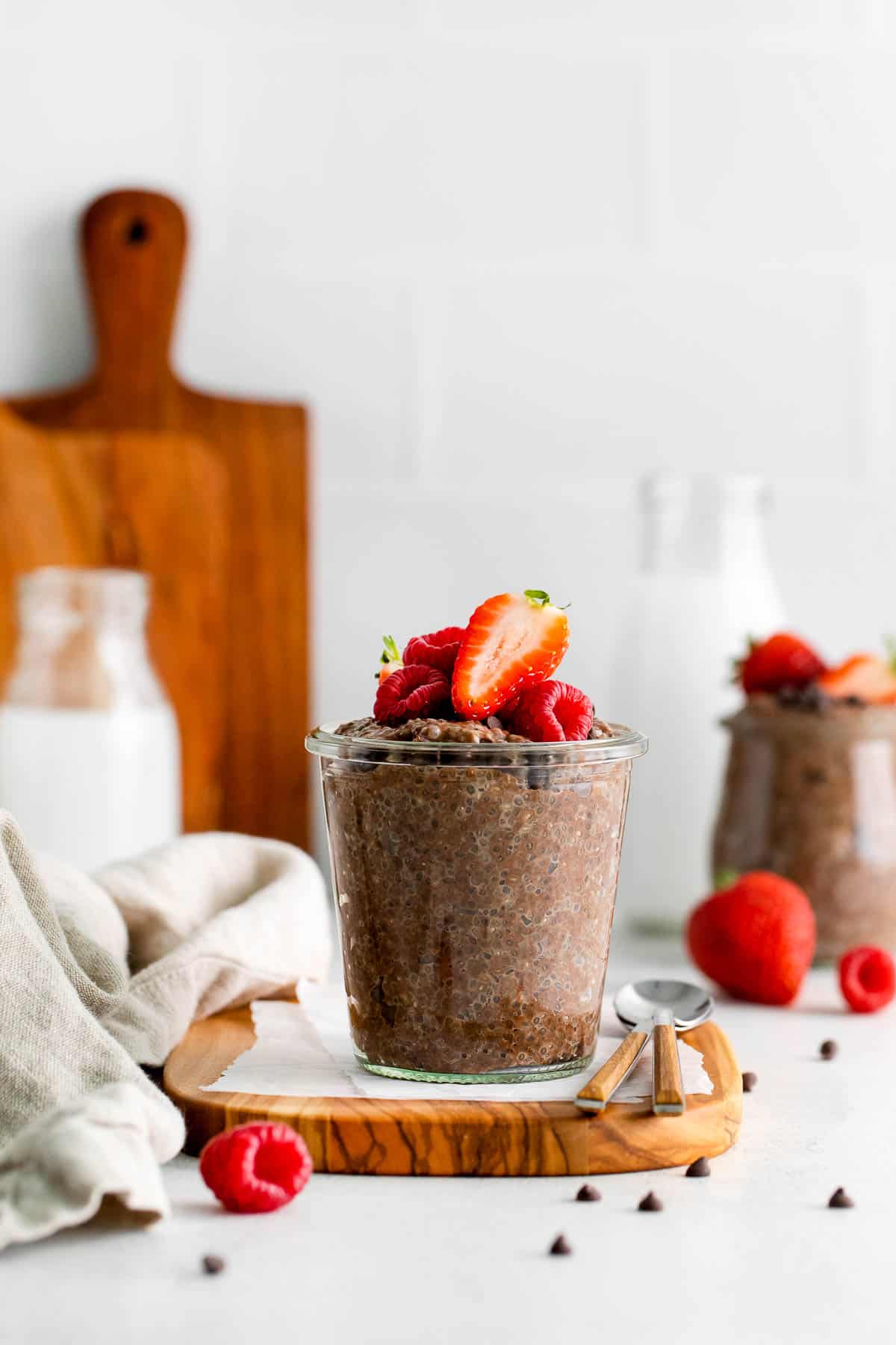 chocolate chia pudding in jar with berries side view.