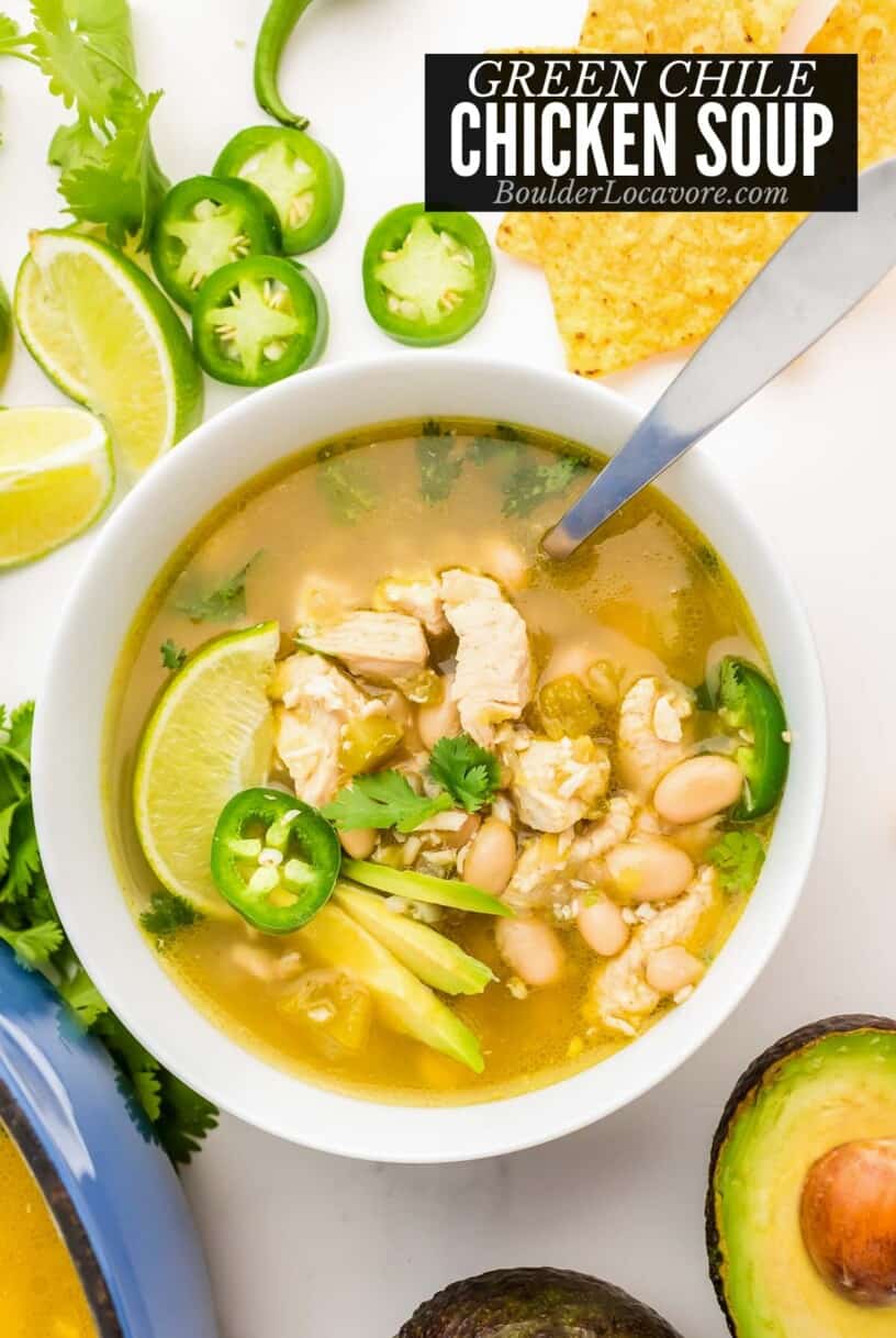 green chile chicken soup in bowl with spoon and toppings