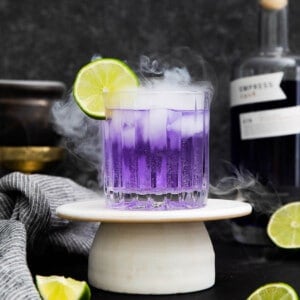 empress gin cocktail with dry ice and lime slice.