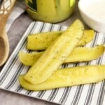 homemade ranch pickles on a striped plate.